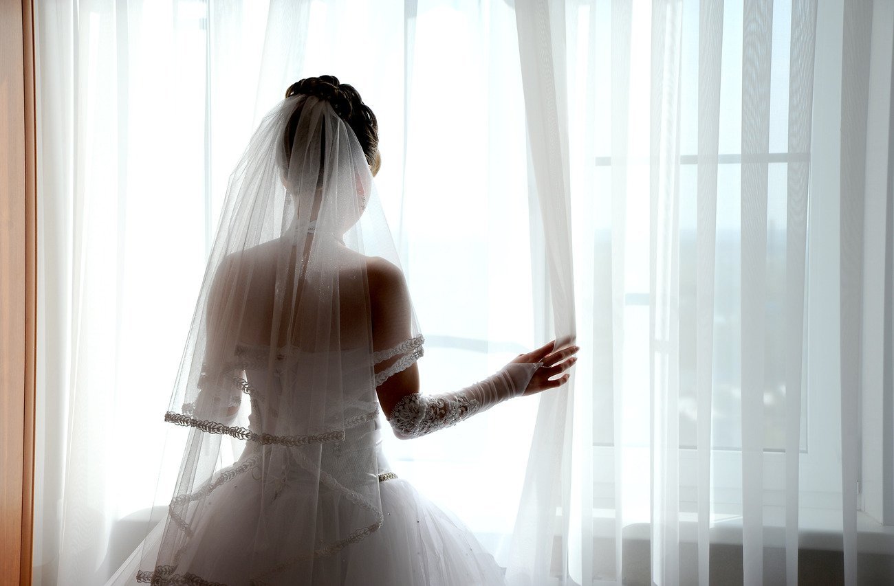 За окном белом платье. Невеста со спины. Девушка в свадебном платье со спины. Невеста брюнетка со спины.